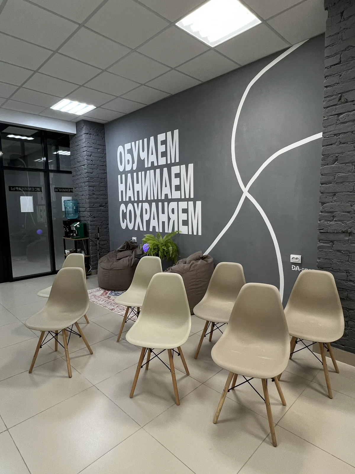 Интерьер зала: кирпичная стена, стулья и стол